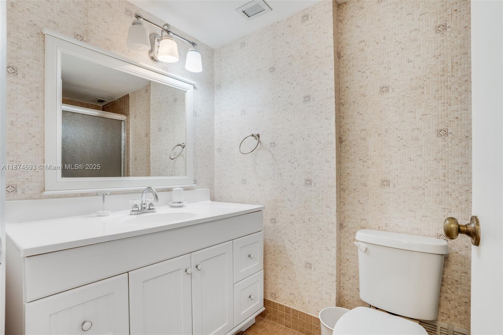 18041 Biscayne Boulevard, Unit 1404 Aventura, FL 33160 - Photo 16 of 22 a bathroom with a sink a toilet and shower