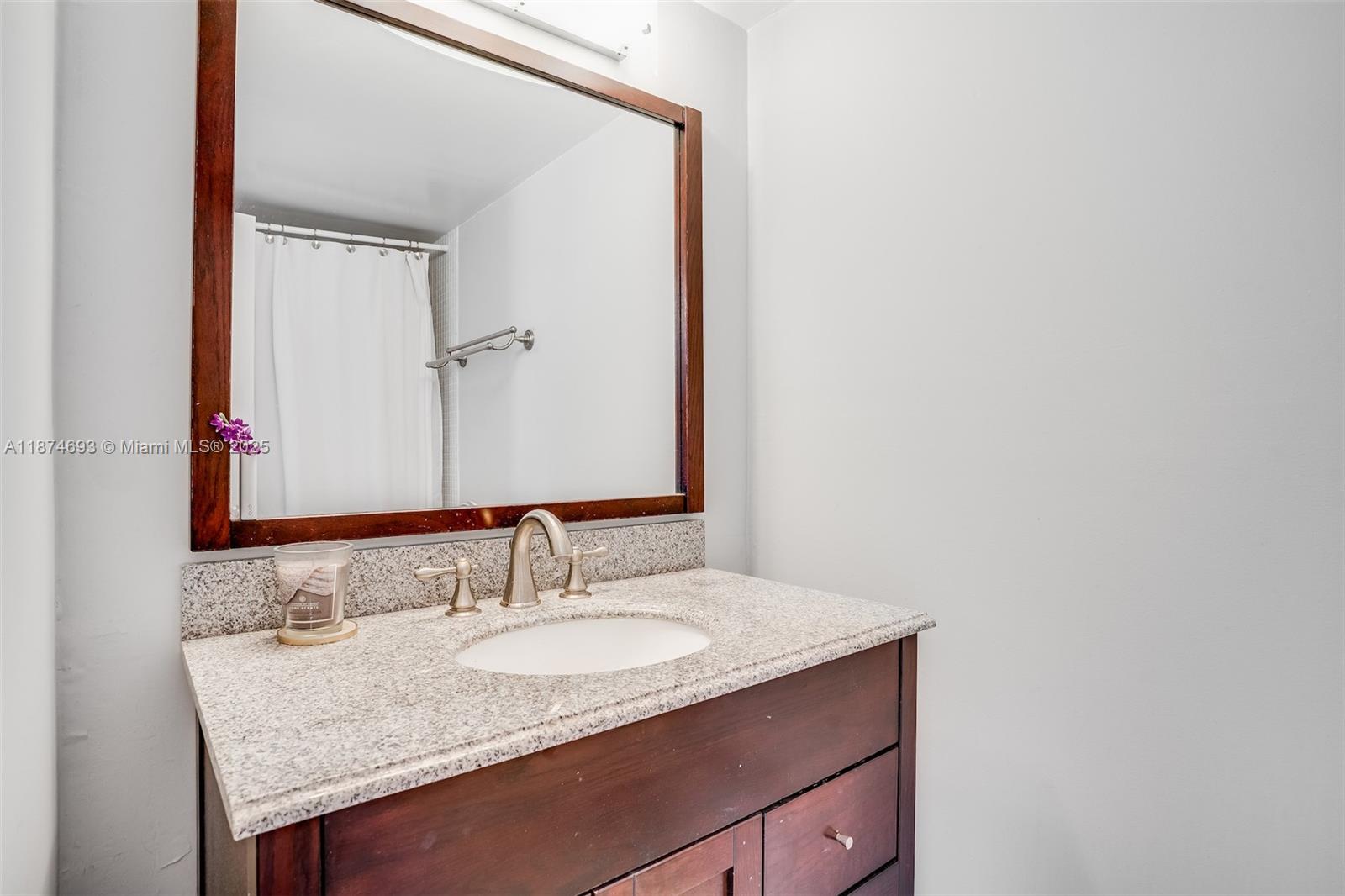 18041 Biscayne Boulevard, Unit 1404 Aventura, FL 33160 - Photo 17 of 22 a bathroom with a granite countertop sink and a mirror