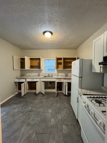 a large kitchen with stainless steel appliances a stove a sink dishwasher and a refrigerator