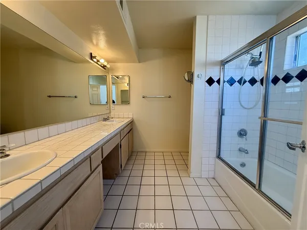 a spacious bathroom with a granite countertop sink mirror and shower