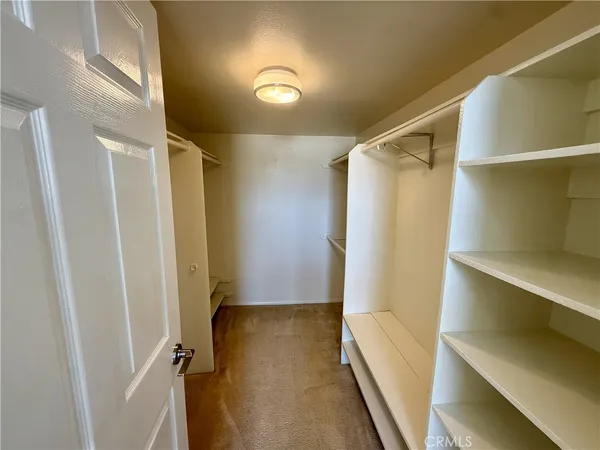 a view of walk in closet with empty racks