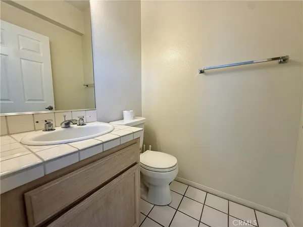 a bathroom with a granite countertop sink toilet and a mirror
