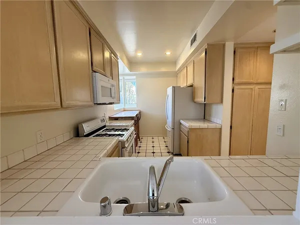 a kitchen with stainless steel appliances granite countertop a sink a stove and a refrigerator