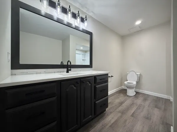 a bathroom with a toilet sink and mirror