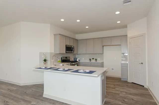 a kitchen with stainless steel appliances a refrigerator sink and microwave