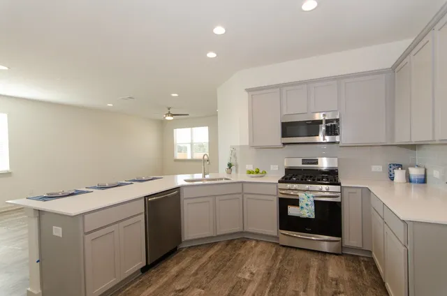 a kitchen with a sink stove top oven and microwave