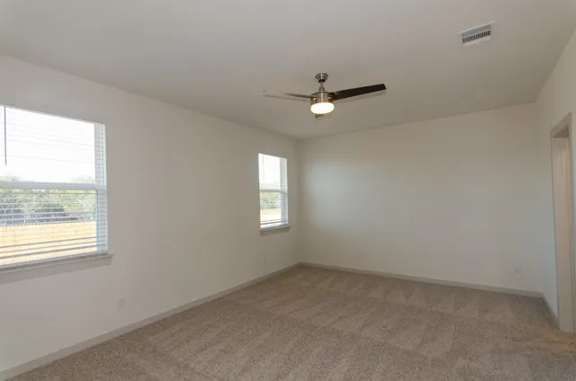 an empty room with a window and a ceiling fan