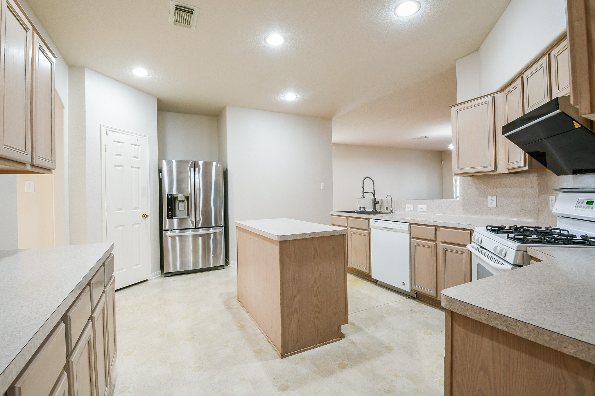 24219 Camillia Ridge Way Katy, TX 77493 - Photo 11 of 32 a kitchen with stainless steel appliances kitchen island granite countertop a refrigerator a sink a stove and white cabinets