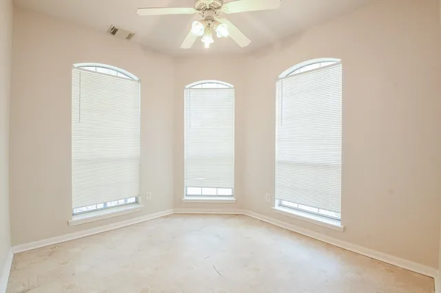 an empty room with windows and closet area