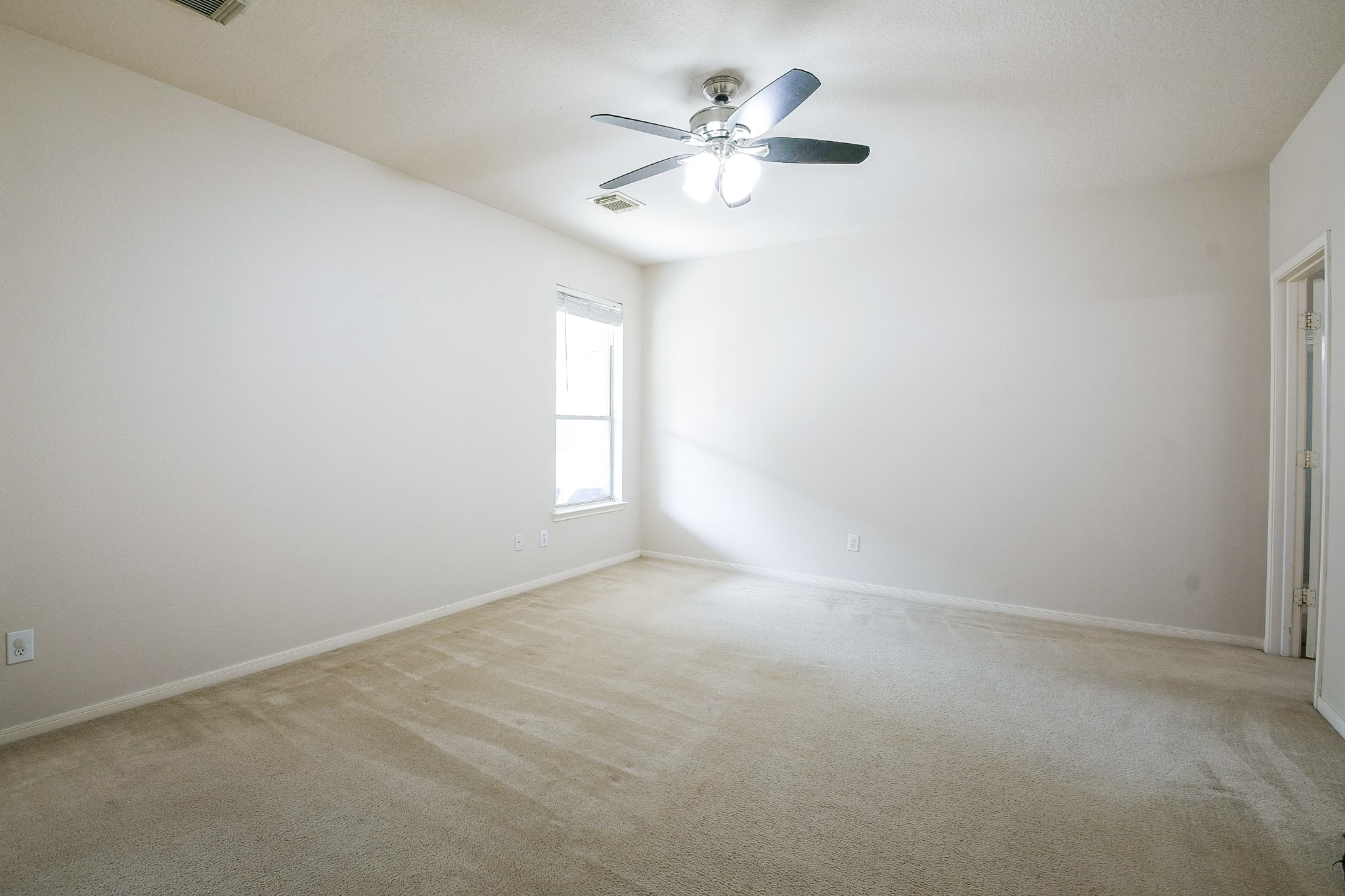 24219 Camillia Ridge Way Katy, TX 77493 - Photo 13 of 32 an empty room with windows and fan