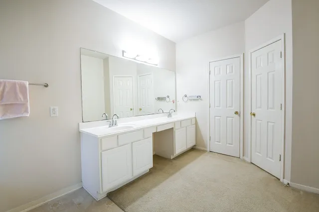 a bathroom with a double vanity sink mirror and bathtub