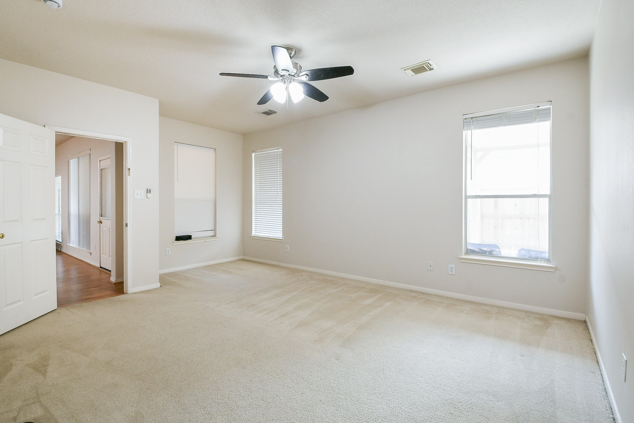 24219 Camillia Ridge Way Katy, TX 77493 - Photo 17 of 32 an empty room with chandelier fan and windows