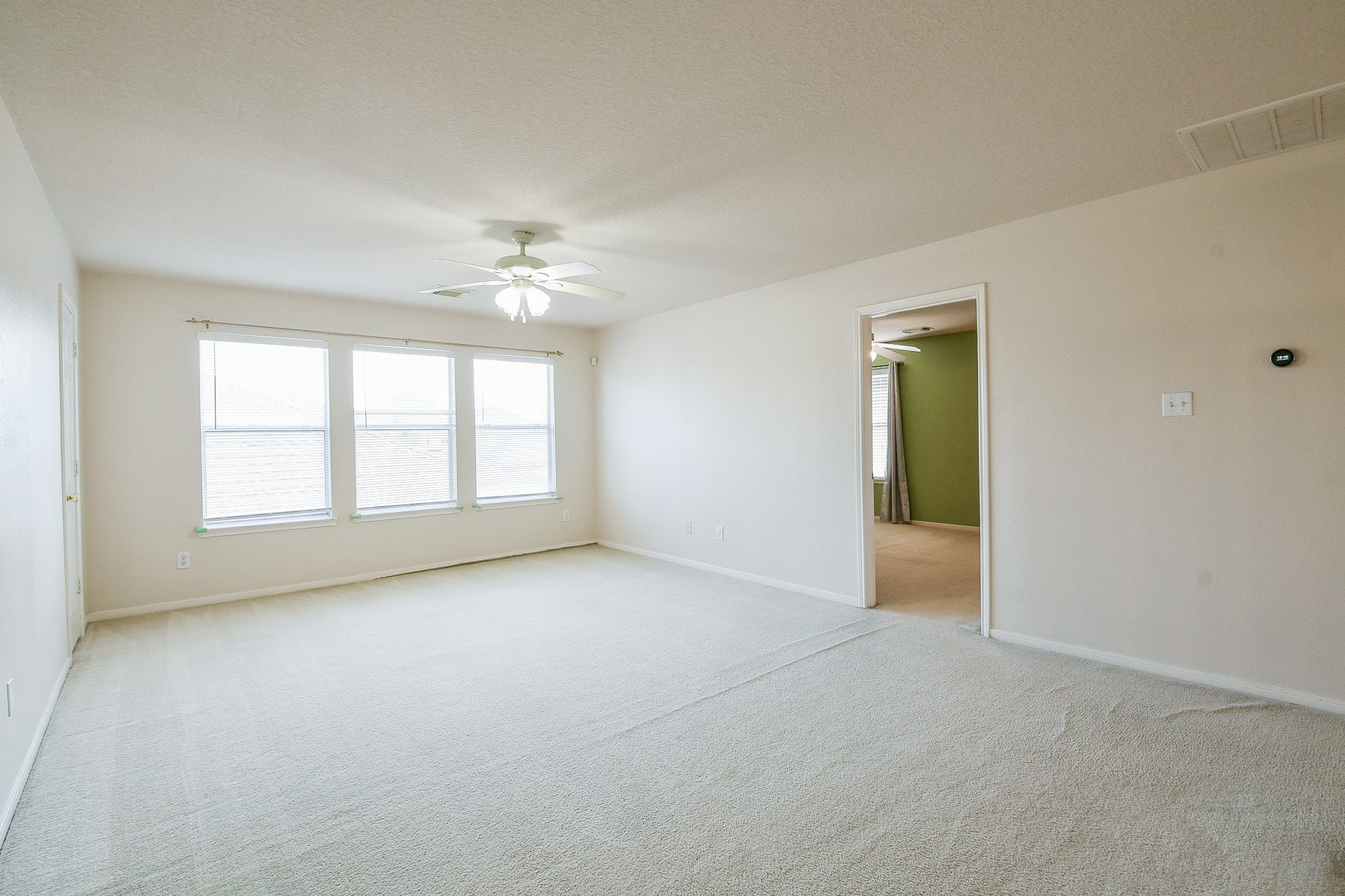 24219 Camillia Ridge Way Katy, TX 77493 - Photo 20 of 32 an empty room with windows and a ceiling fan