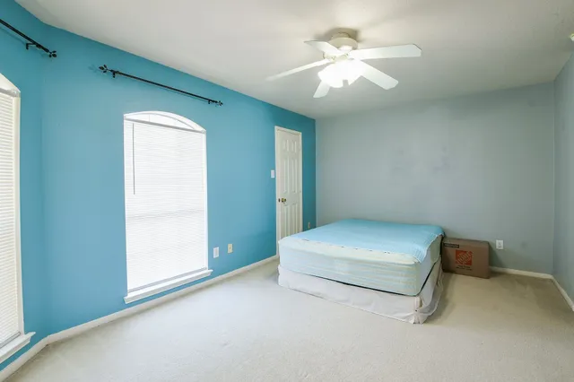 a living room with a bed and a ceiling fan