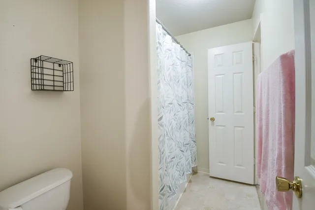 a bathroom with a shower curtain and a toilet