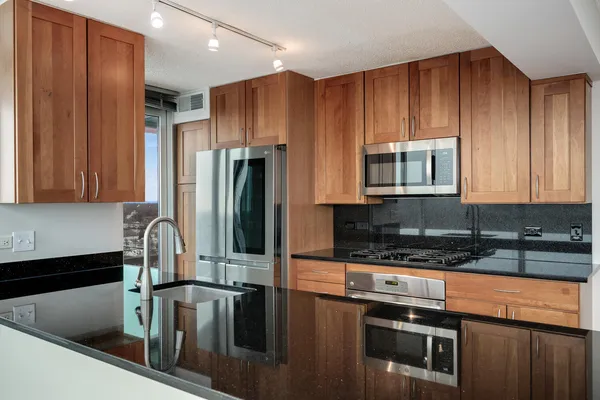 a kitchen with stainless steel appliances granite countertop a stove a refrigerator and a microwave