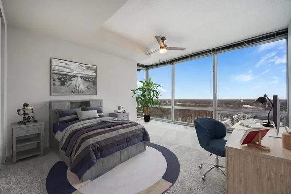 a spacious bedroom with a bed a couch and a potted plant