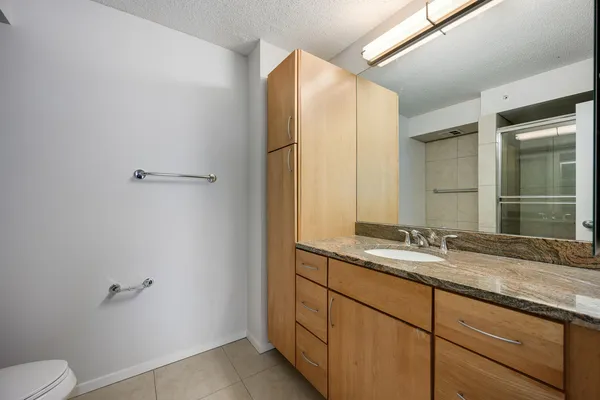 a bathroom with a granite countertop sink mirror and toilet