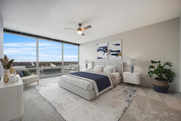 a spacious bedroom with a bed a couch and a potted plant