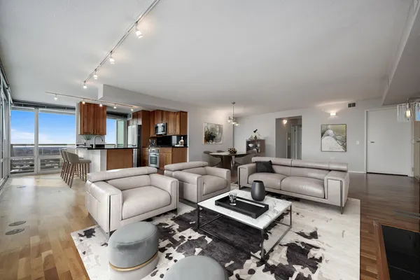 a living room with furniture flat screen tv and kitchen view