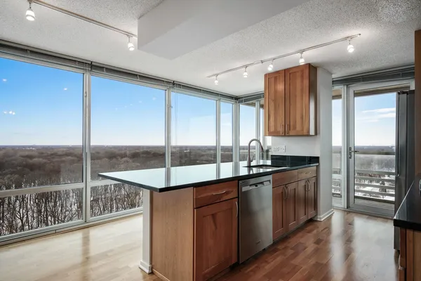a kitchen with stainless steel appliances granite countertop a sink counter space cabinets and a large window