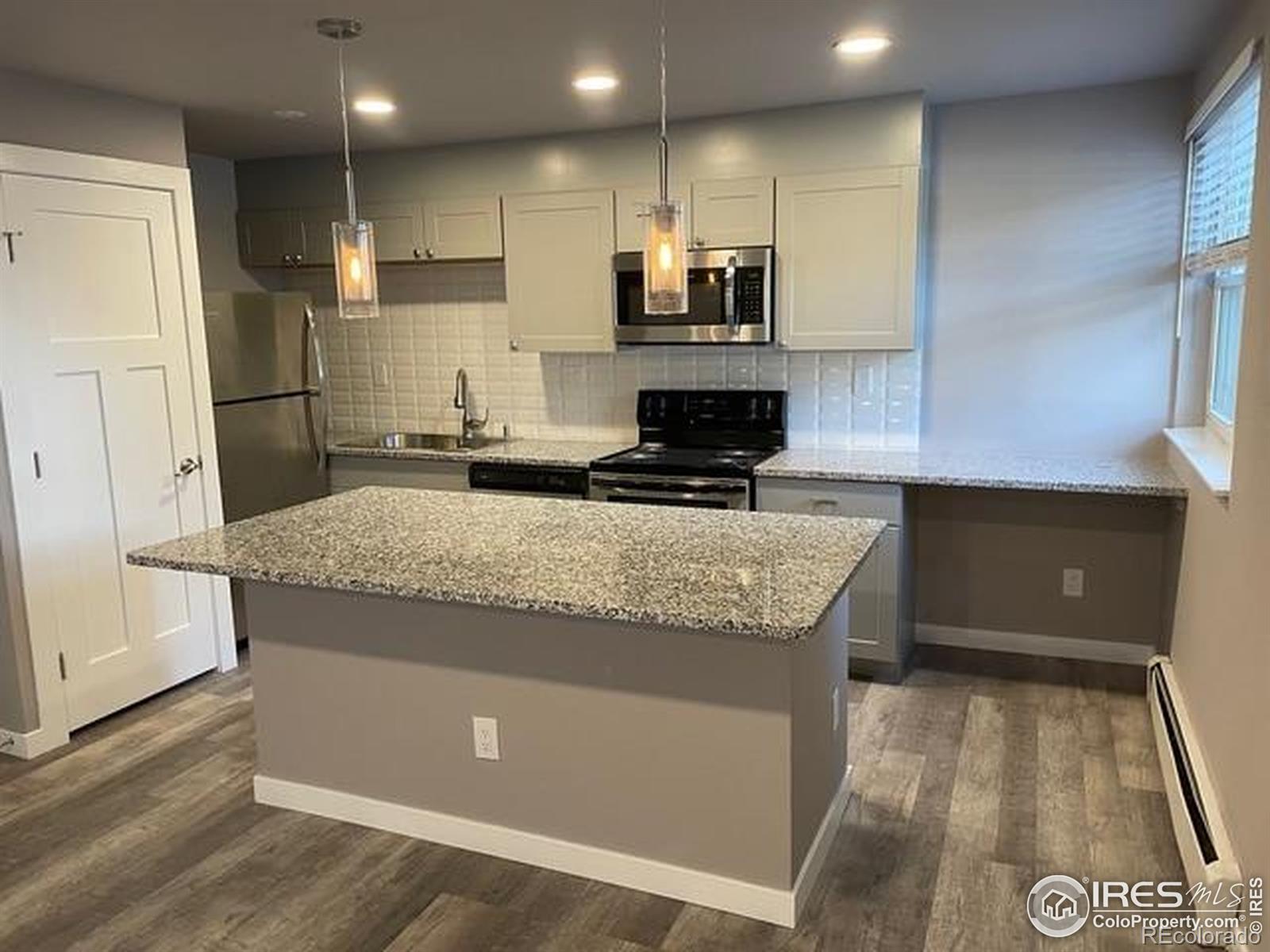 3035 Oneal Parkway, Unit T11 Boulder, CO 80301 - Photo 4 of 28 a kitchen with kitchen island granite countertop a stove and a refrigerator