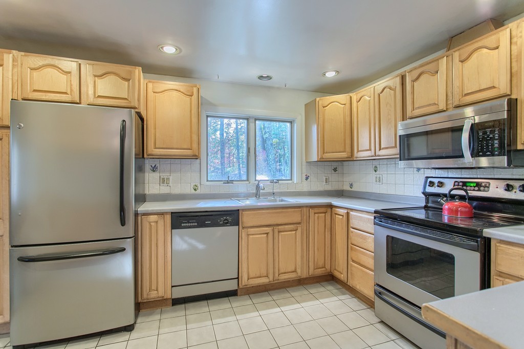 49 Clarissa Road Chelmsford, MA 01824 - Photo 6 of 25 a kitchen with stainless steel appliances granite countertop a refrigerator sink stove microwave and cabinets