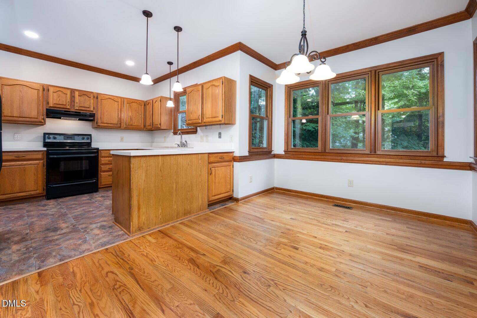 5020 Celbridge Place Raleigh, NC 27613 - Photo 18 of 52 a kitchen with stainless steel appliances granite countertop a stove and a wooden floors
