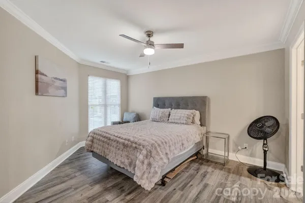 a bedroom with a bed a window and a ceiling fan