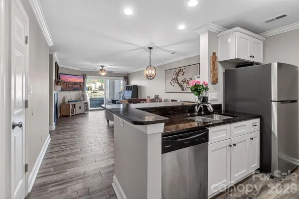 a kitchen with stainless steel appliances granite countertop a sink stove and refrigerator