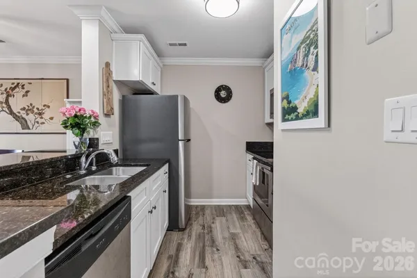 a kitchen with granite countertop a sink stove and refrigerator