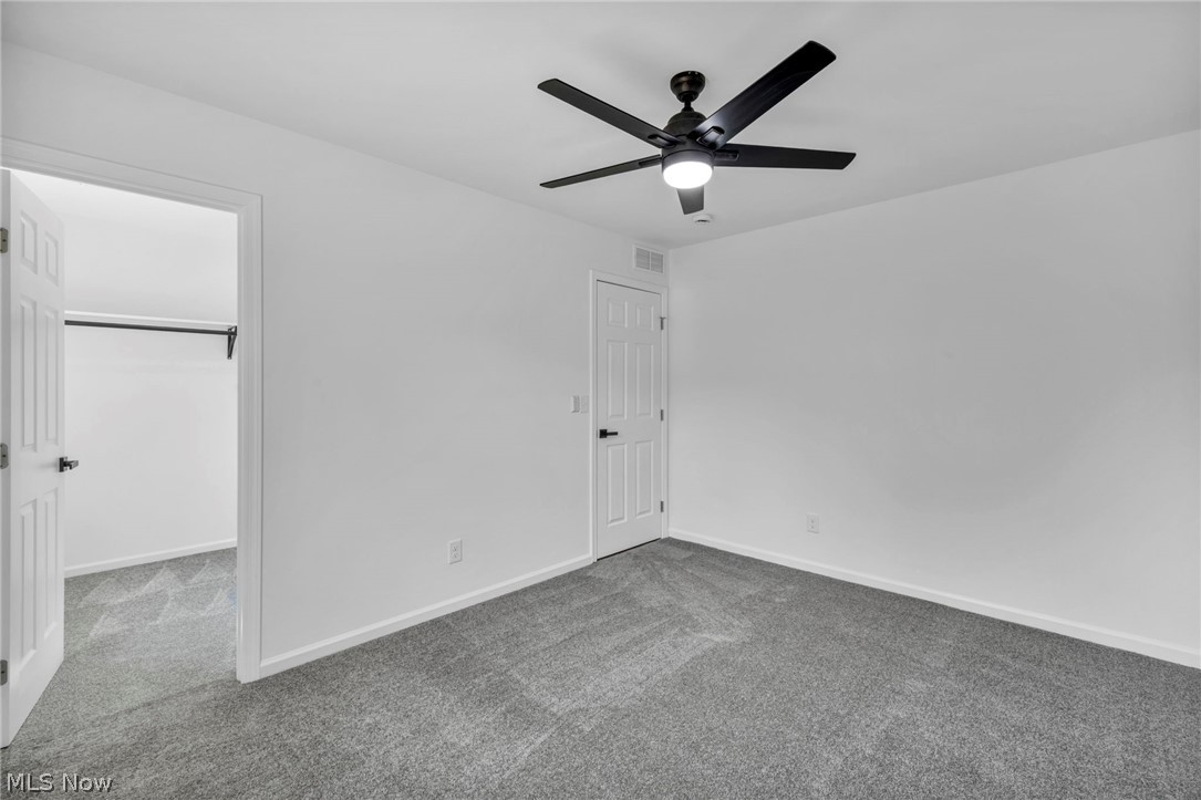 7602 Hickory Road Bedford, OH 44146 - Photo 17 of 36 Unfurnished bedroom with carpet, a spacious closet, and a ceiling fan