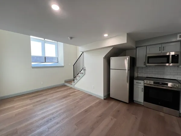 wooden floor in an empty room with a kitchen