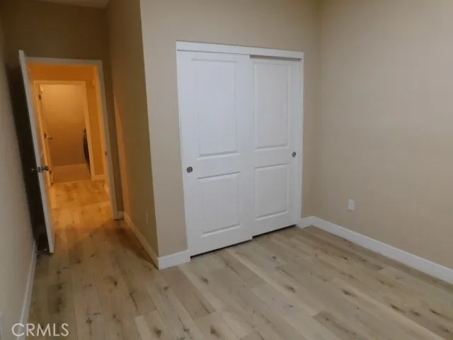 an empty room with wooden floor and entrance