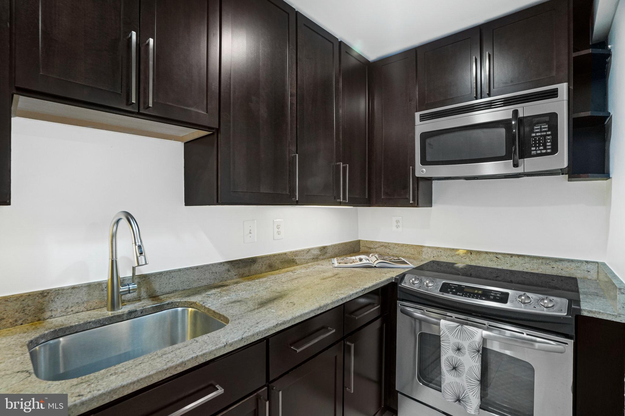 2627 Adams Mill Road Northwest, Unit T3 Washington, DC 20009 - Photo 11 of 19 a kitchen with granite countertop a sink stainless steel appliances and cabinets