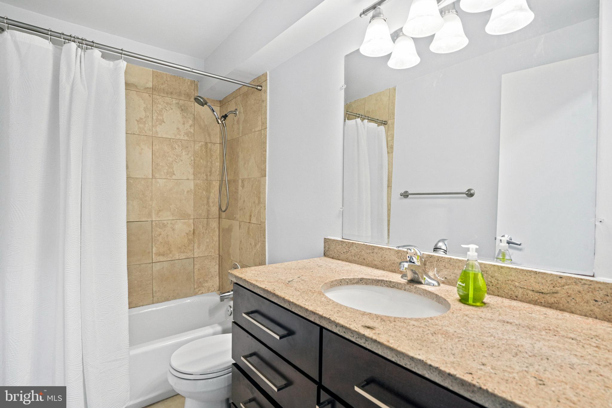 2627 Adams Mill Road Northwest, Unit T3 Washington, DC 20009 - Photo 17 of 19 a bathroom with a granite countertop sink a toilet and shower