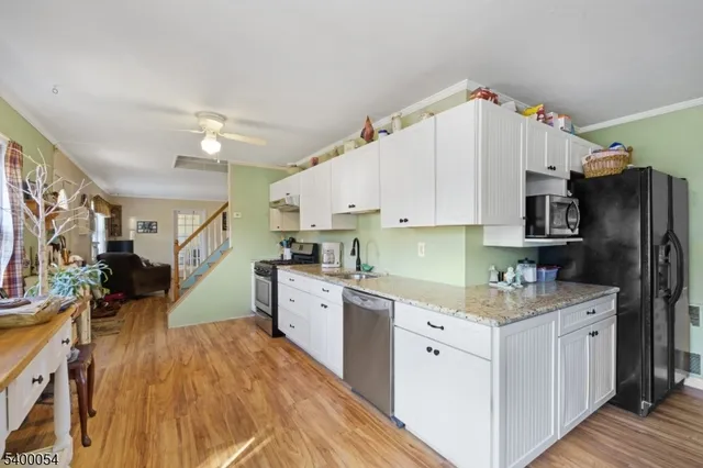 a kitchen that has a lot of cabinets a sink and appliances in it