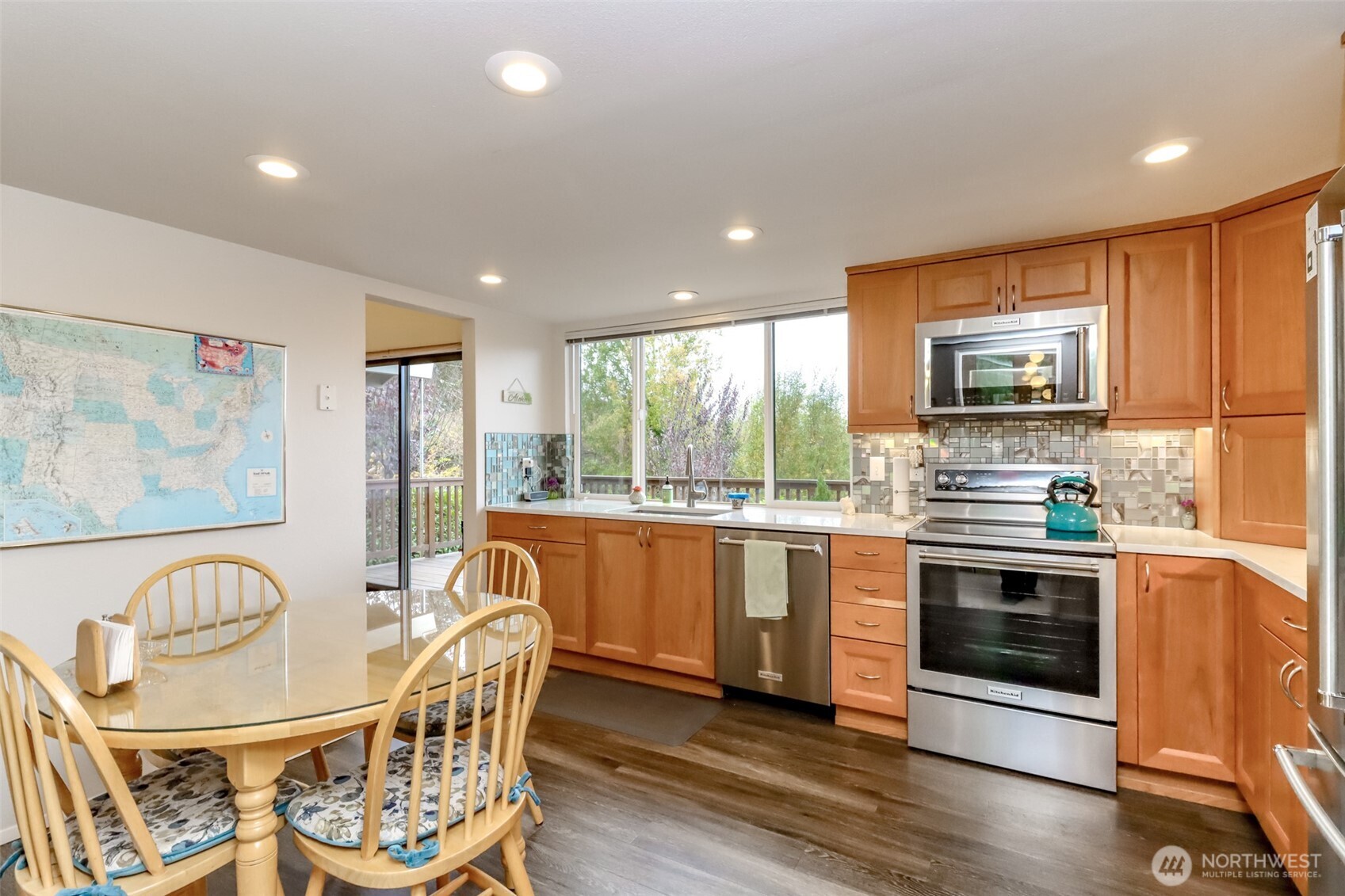 29419 4th Avenue South Federal Way, WA 98003 - Photo 12 of 38 a kitchen with stainless steel appliances granite countertop a stove a sink a microwave a dining table and chairs with wooden floor