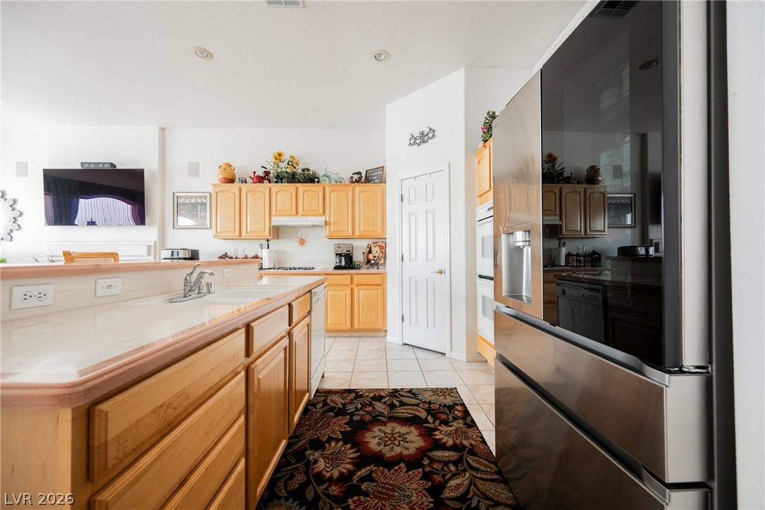 5494 Pine Ranch Street Las Vegas, NV 89113 - Photo 32 of 54 A well-appointed kitchen offers ample counter space, rich wood cabinetry, and a full suite of stainless steel appliances.
