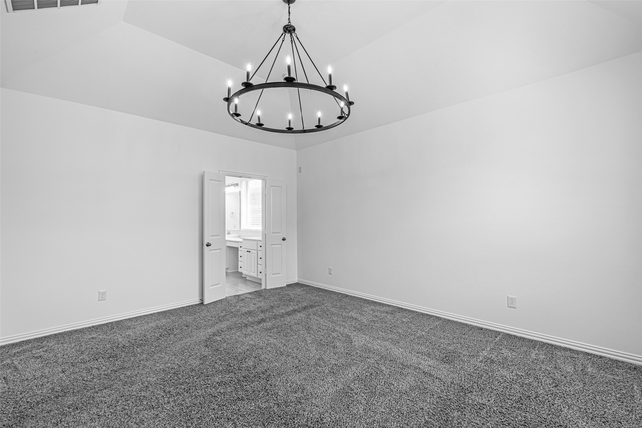 23635 Kingston Ridge Way Katy, TX 77493 - Photo 15 of 36 The primary features a clean, spacious layout with a stylish chandelier adding elegance, and double doors open to the en-suite bathroom