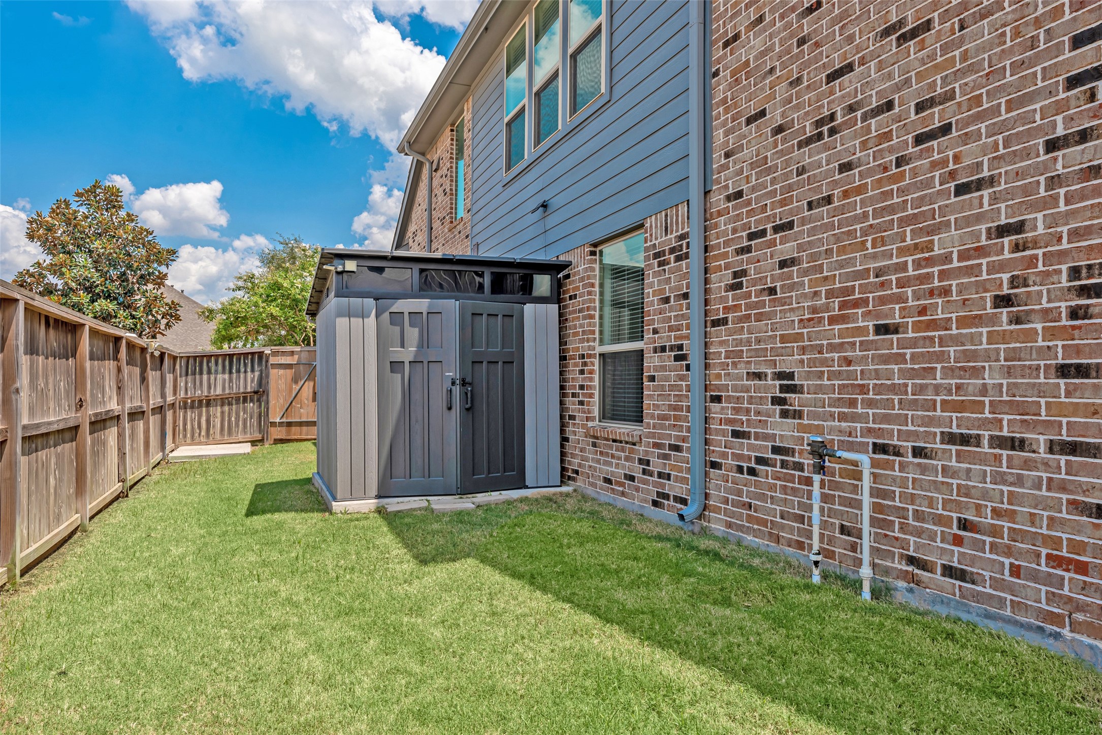 23635 Kingston Ridge Way Katy, TX 77493 - Photo 34 of 36 Side yard space featuring a modern storage shed, providing convenient outdoor storage.