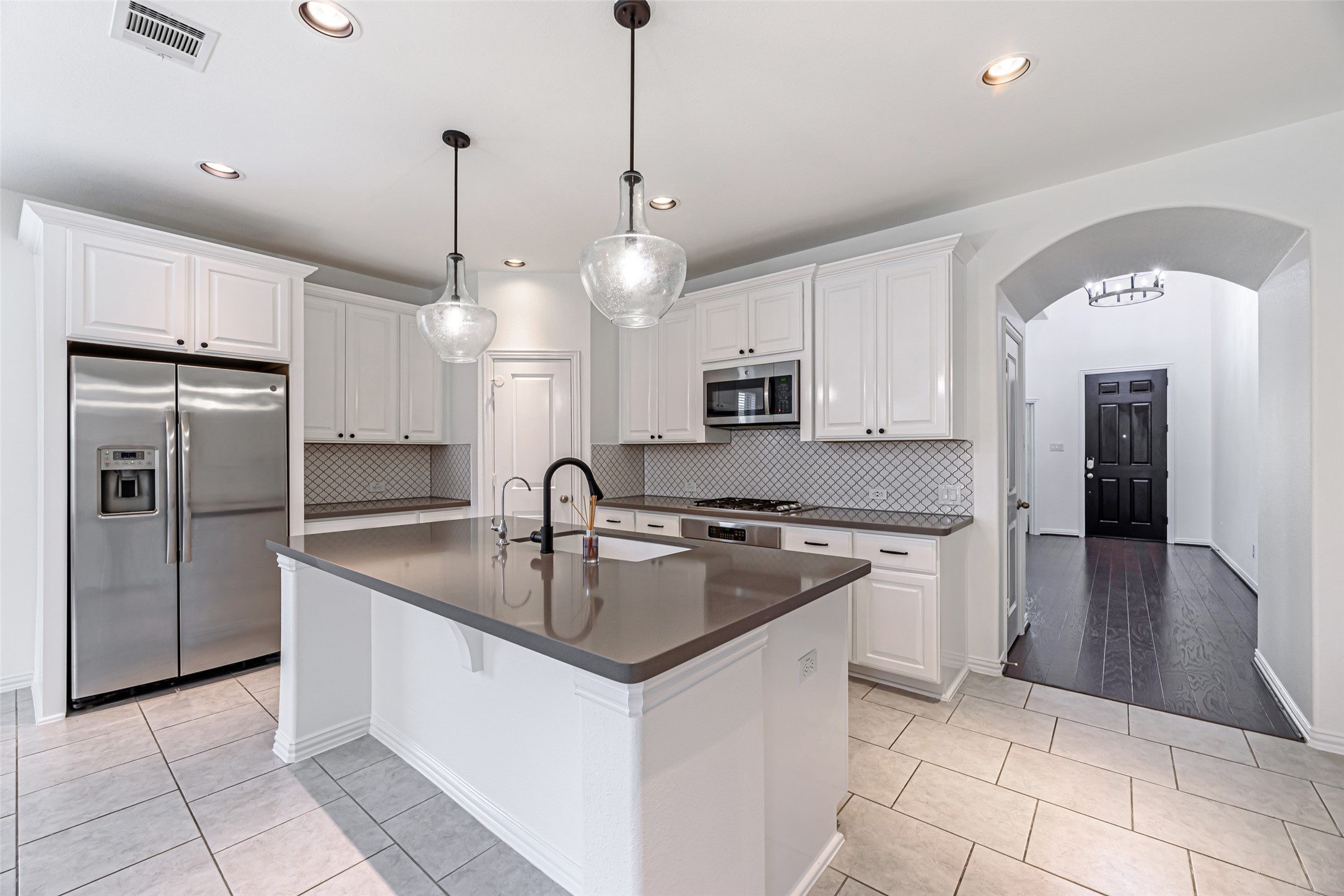 23635 Kingston Ridge Way Katy, TX 77493 - Photo 5 of 36 This kitchen features modern white cabinetry, stainless steel appliances, & quartz countertops