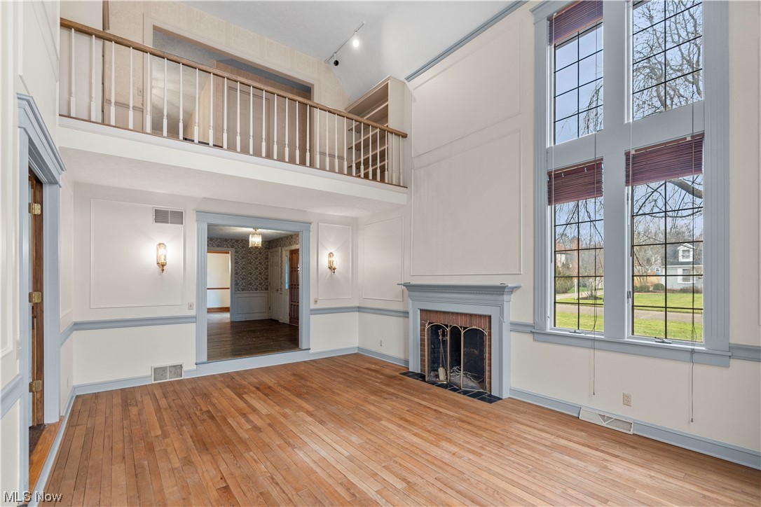 4017 Bramshaw Road Northwest Canton, OH 44718 - Photo 6 of 42 Step down from foyer into the formal living room showcasing the massive windows, hardwood flooring, and wood burning / gas fireplace