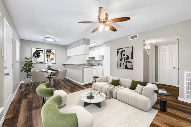 a living room with furniture kitchen view and a window
