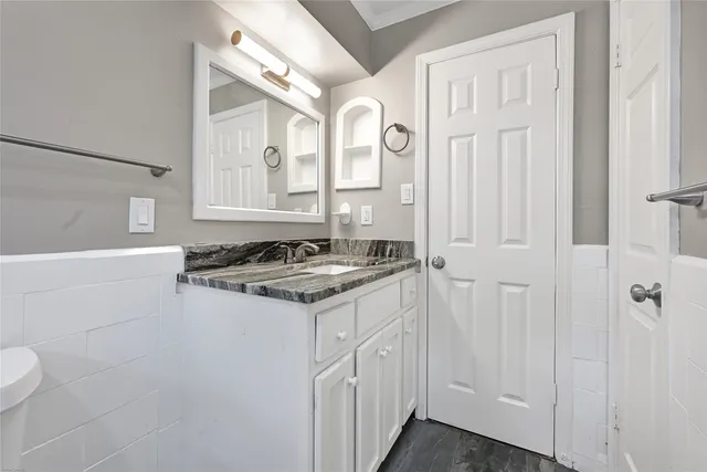 a bathroom with a granite countertop sink and a mirror