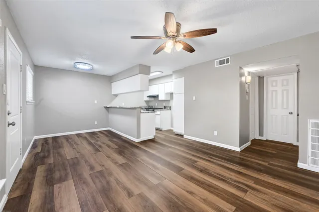 a view of empty room with wooden floor and window