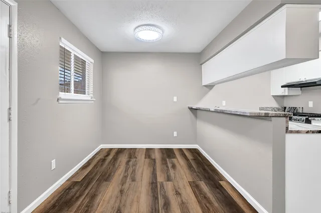 a view of a room with wooden floor