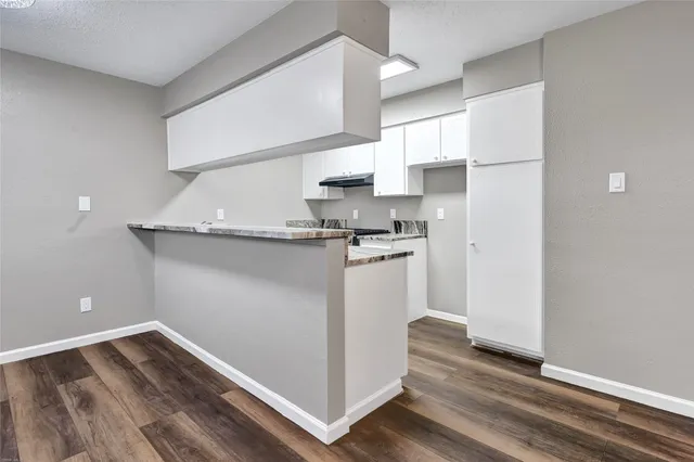 a kitchen with granite countertop white cabinets and white appliances
