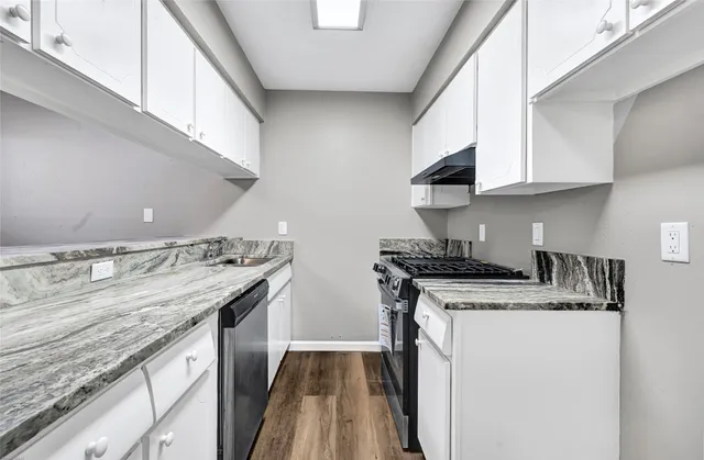 a kitchen with stainless steel appliances granite countertop a sink stove and cabinets