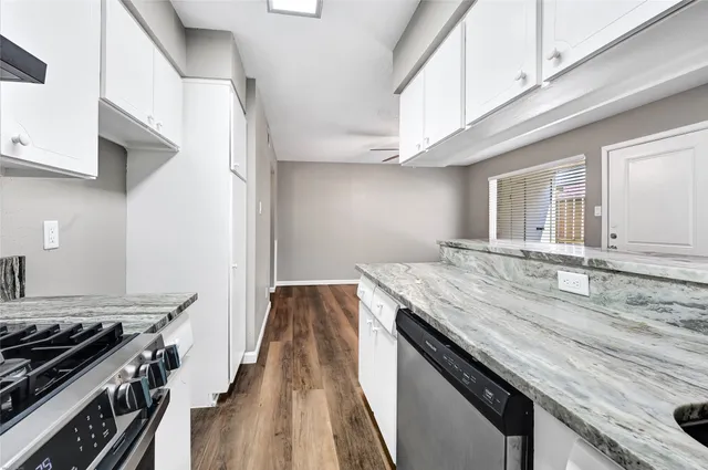 a kitchen with granite countertop a stove and a sink